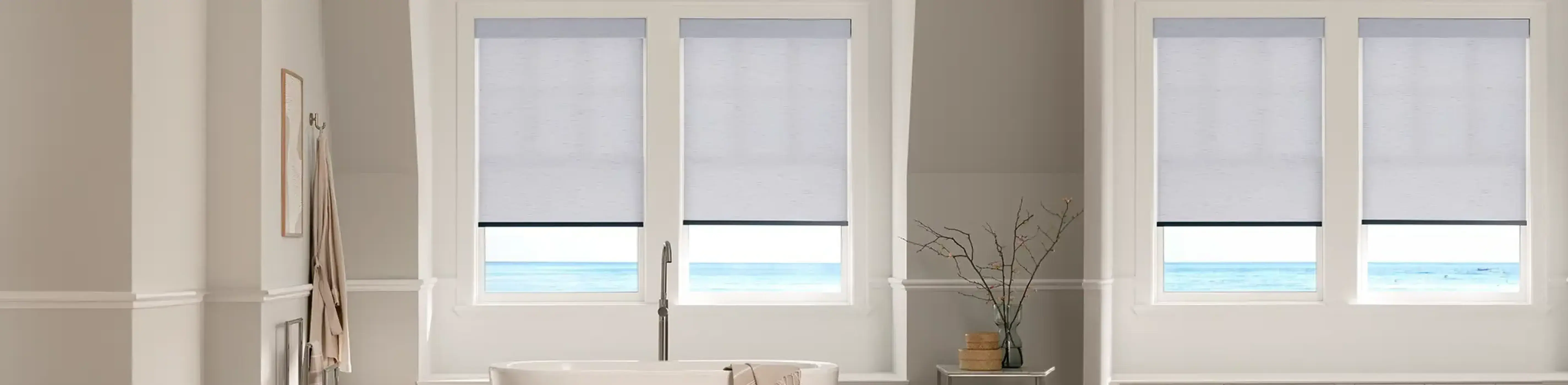 white roller shades in a brightly lit living room facing the ocean
