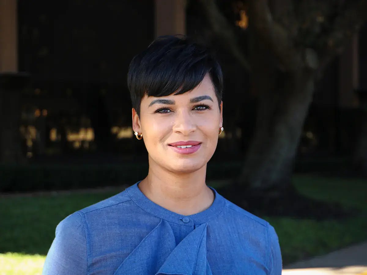 Woman with short dark hair and a blue shirt.