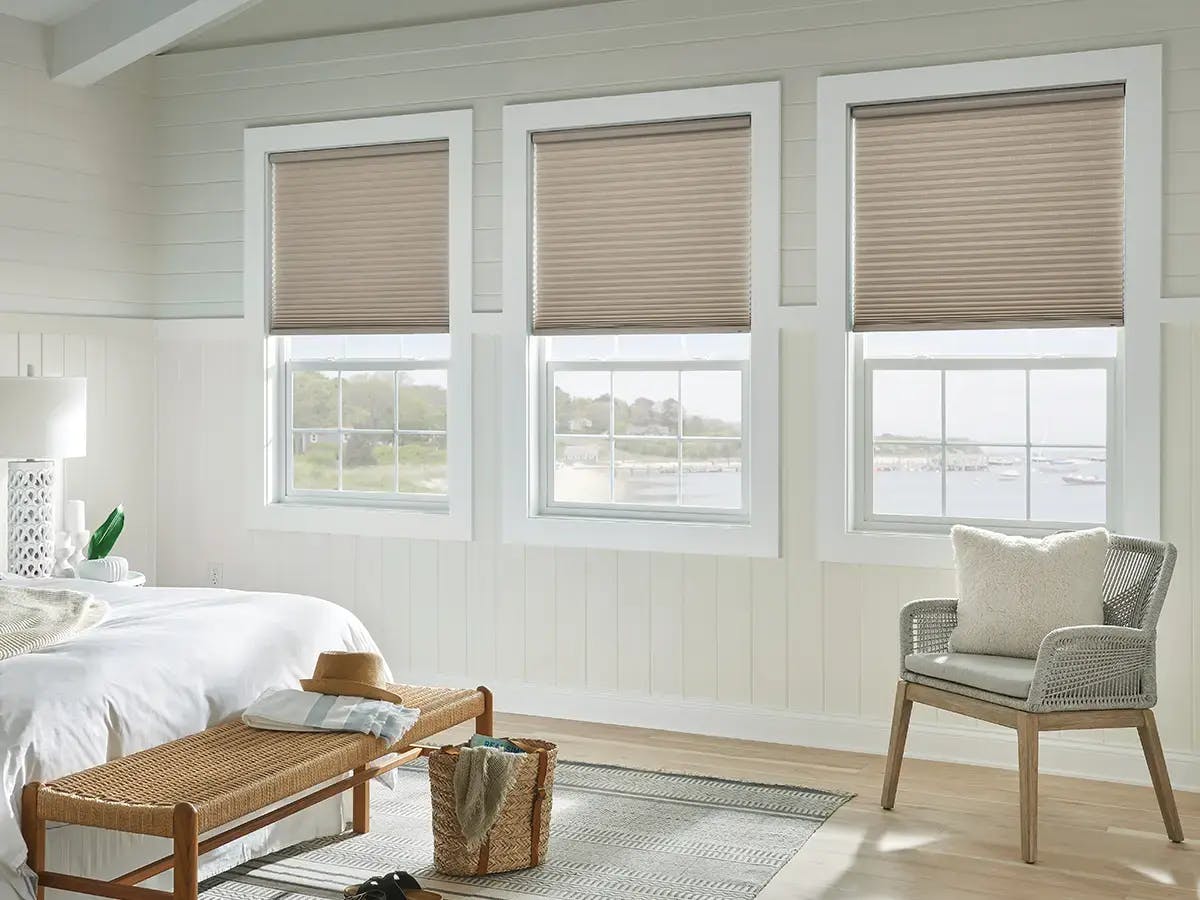 Bedroom features beige cellular shades.