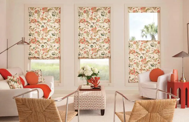 Shades with an orange and peach floral pattern in a living room
