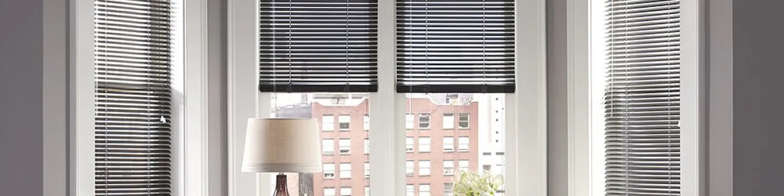 Metal mini blinds in the bay window of an office nook