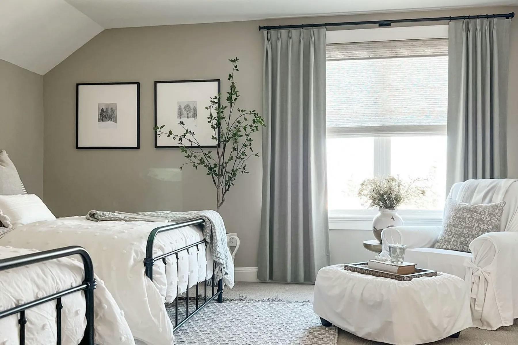 Bedroom with white furniture and neutral wall paint. The window has light gray woven wood shades layered under darker gray drapes.