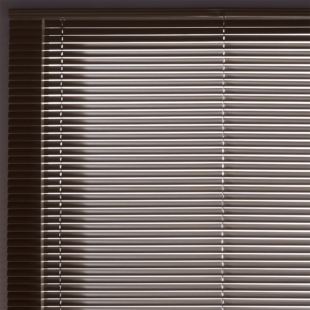 Bedroom window with classic aluminum mini blinds offering simple and affordable light control