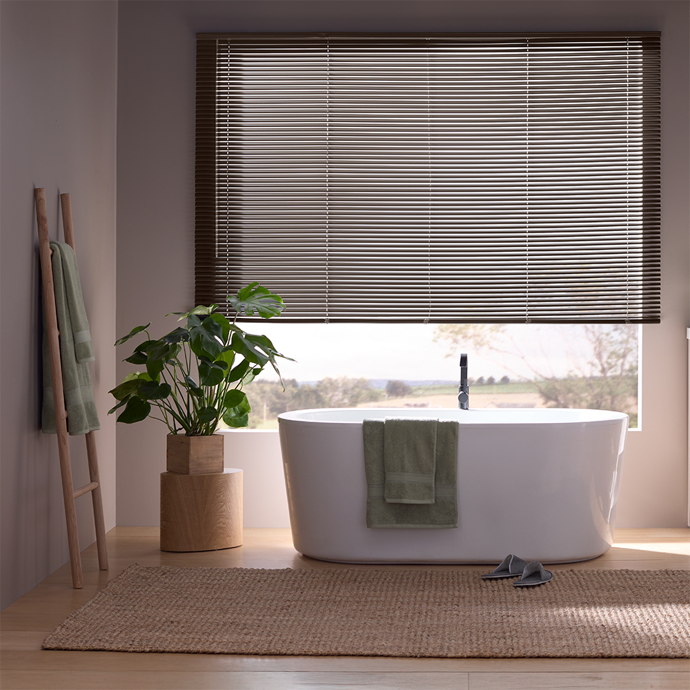 Bedroom window with classic aluminum mini blinds offering simple and affordable light control