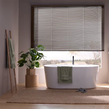 Bedroom window with classic aluminum mini blinds offering simple and affordable light control
