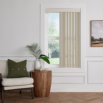 Neutral living space with beige vertical blinds on a tall window, styled with a wooden side table, green pillow, and potted plant