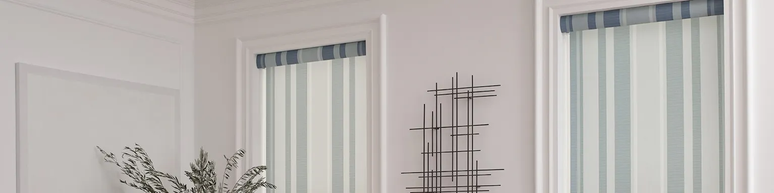 Striped roller shades with blue tones against an off-white wall