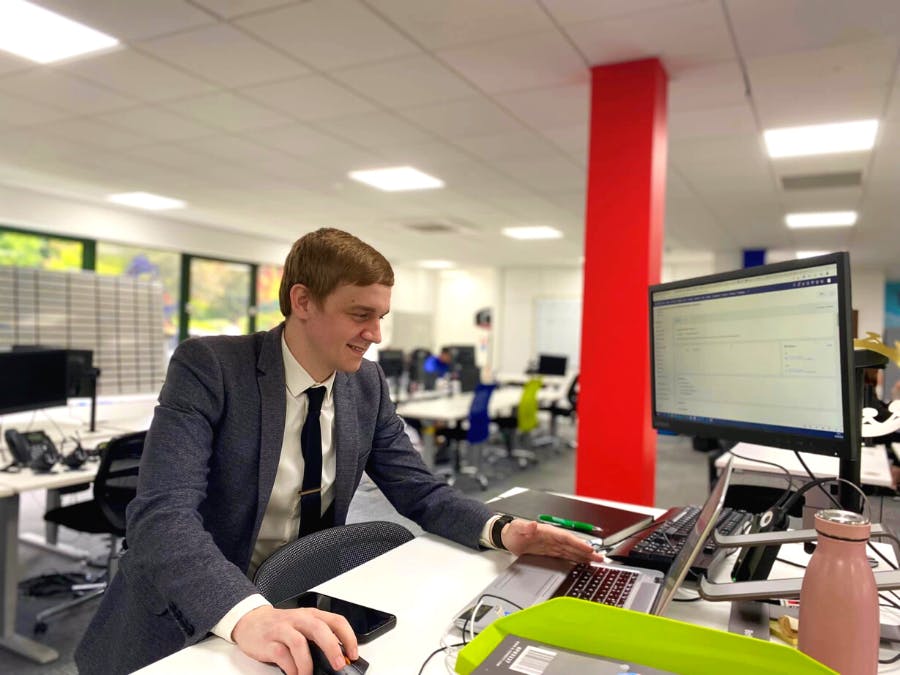 Nathan standing at a desk, working on a computer.
