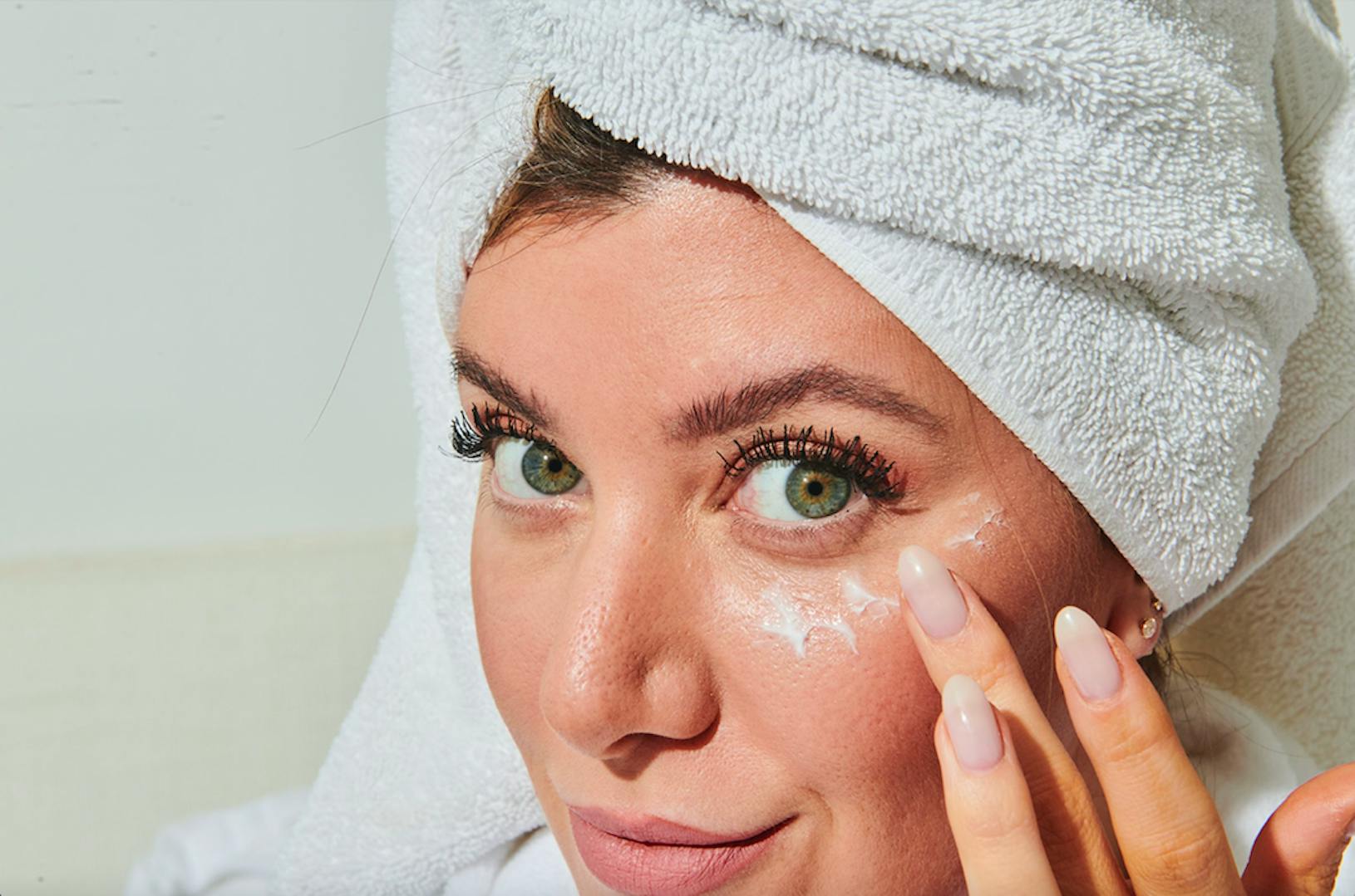 Stephanie Gee in hair towel applying eye cream