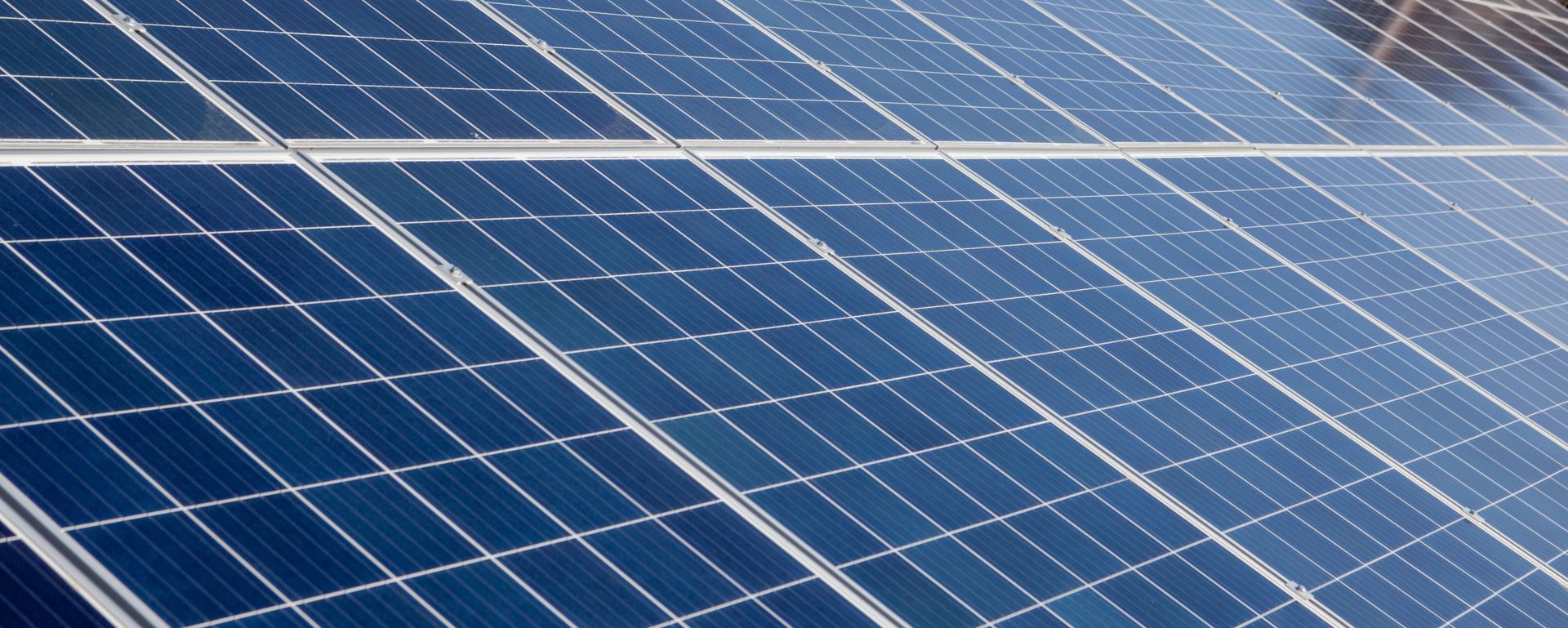 Mehrere polykristalline Solarmodule mit blauen, quadratischen Zellen auf einem Dach