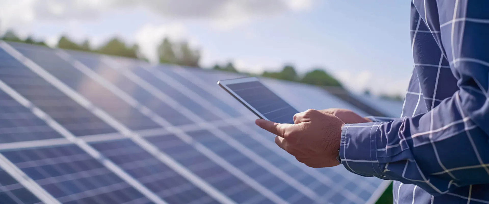 Techniker prüft den Wirkungsgrad einer Photovoltaikanlage mit einem Tablet vor Solarmodulen | Gelb Solar