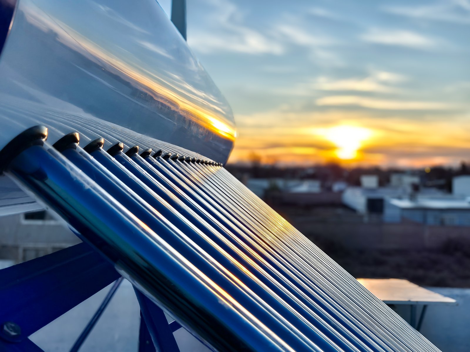 Vakuumröhrenkollektor einer Solarthermieanlage auf dem Dach bei Sonnenuntergang