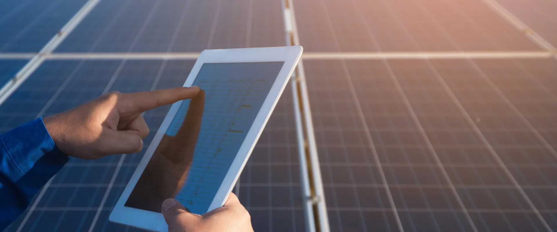 Person prüft den Solarertrag der PV-Anlage auf einem Tablet vor Solarmodulen Person prüft den Solarertrag der PV-Anlage auf einem Tablet vor Solarmodulen