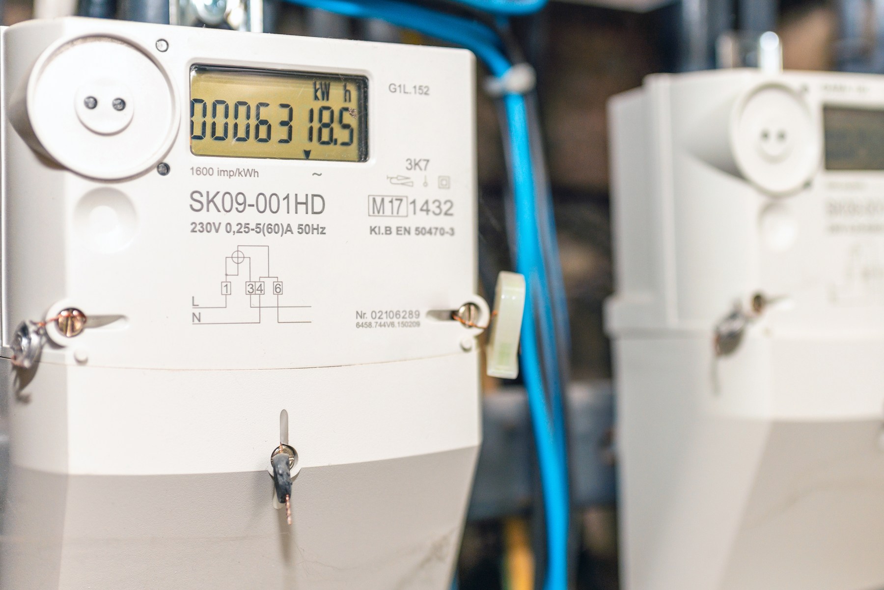 Digitaler Stromzähler mit LCD-Display zeigt Verbrauch in kWh, Nahaufnahme im Zählerschrank