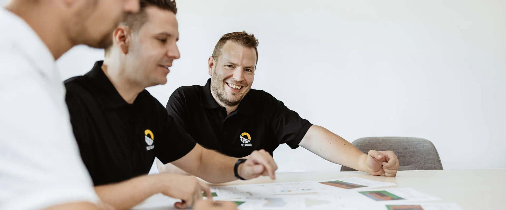 Gelb Solar Team sitzt mit einem Kunden zusammen und erklärt die Funktionsweise eines Stromspeichers Gelb Solar Team sitzt mit einem Kunden zusammen und erklärt die Funktionsweise eines Stromspeichers