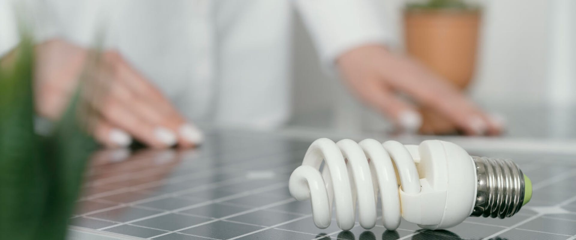 Glühbirne mit Photovoltaik im Hintergrund