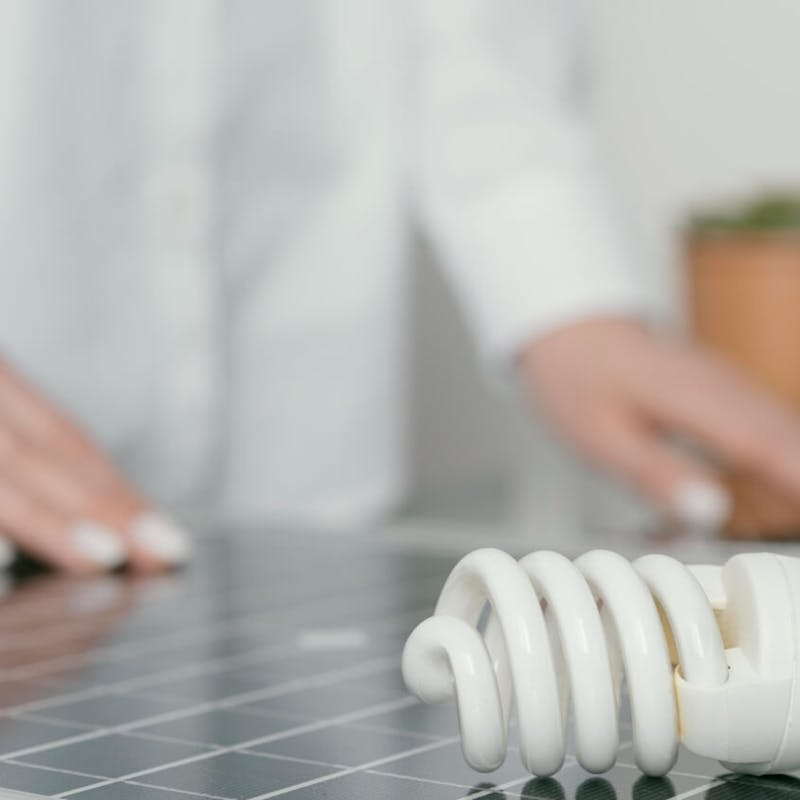 Glühbirne mit Photovoltaik im Hintergrund