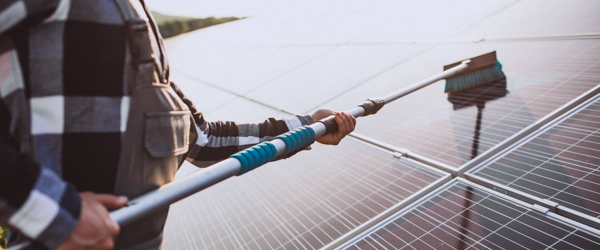 Mann, der eine PV-Anlage reinigt