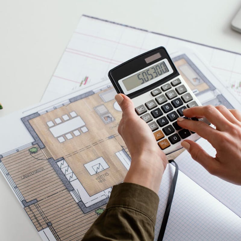 Frau berechnet die optimale kWp-Leistung einer Solaranlage auf Basis eines Hausplans – Planung der Anlagengröße im Kontext von Photovoltaik