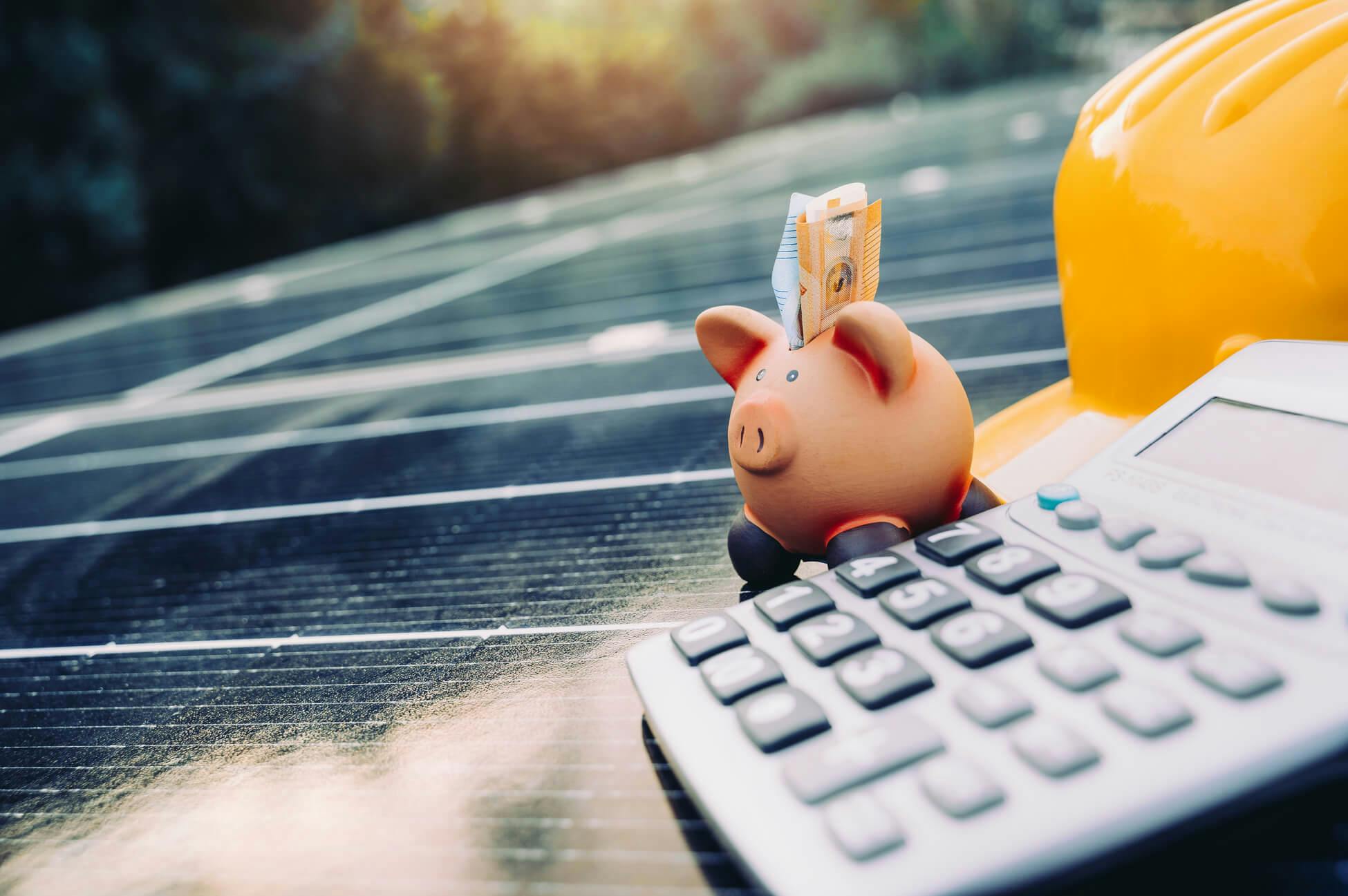 Sparschwein, dass auf einer Solaranlage steht