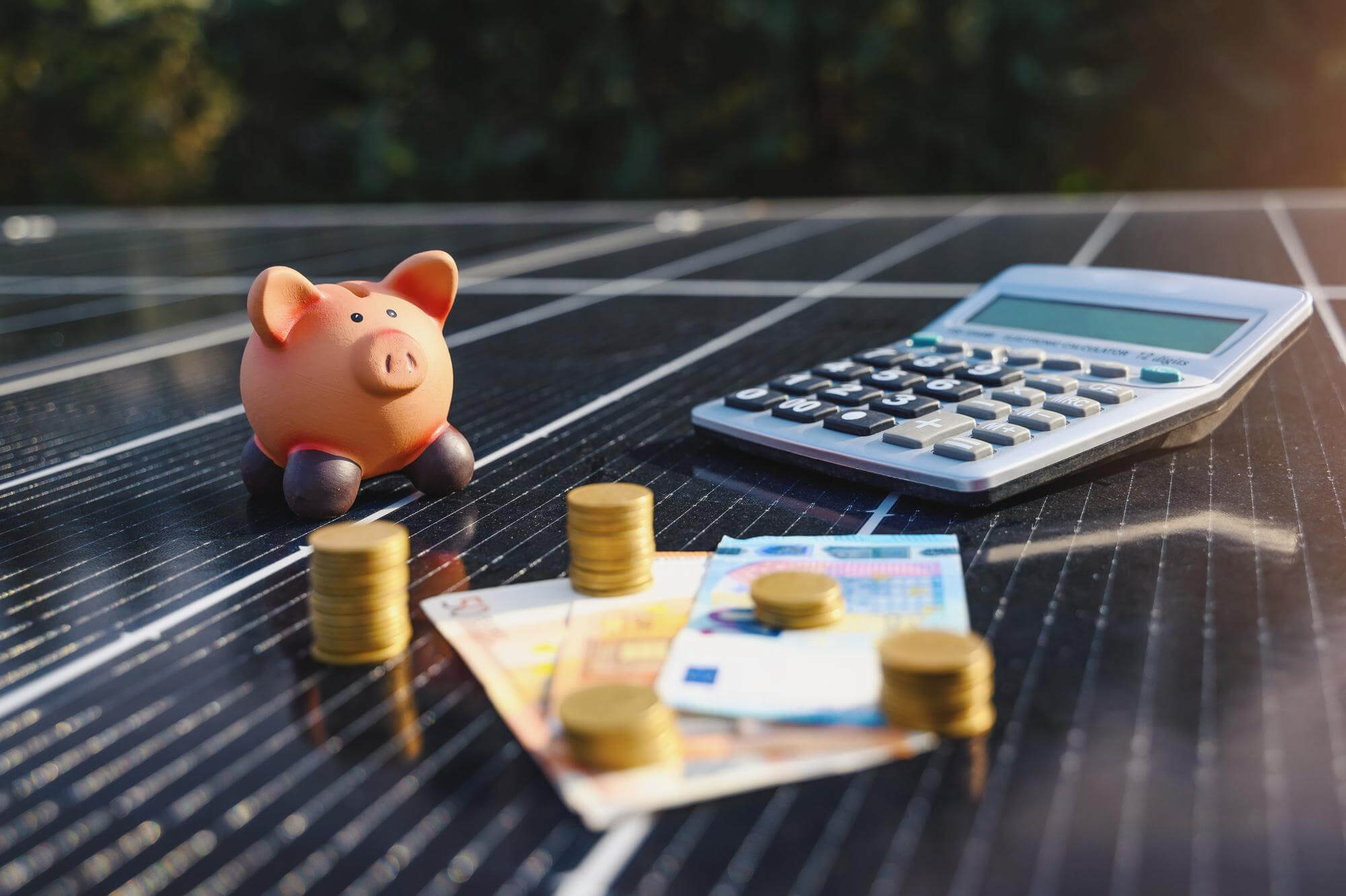 Sparschwein Geld und Taschenrechner auf einer Solaranlage