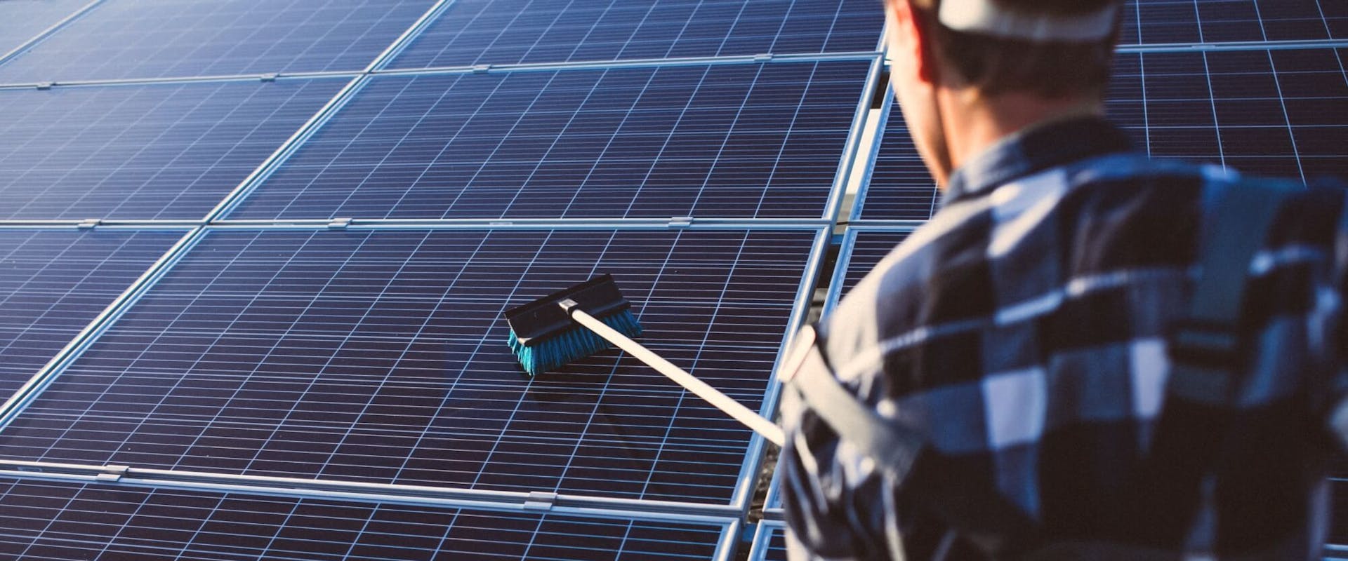 Mann reinigt eine Solaranlage Mann reinigt eine Solaranlage