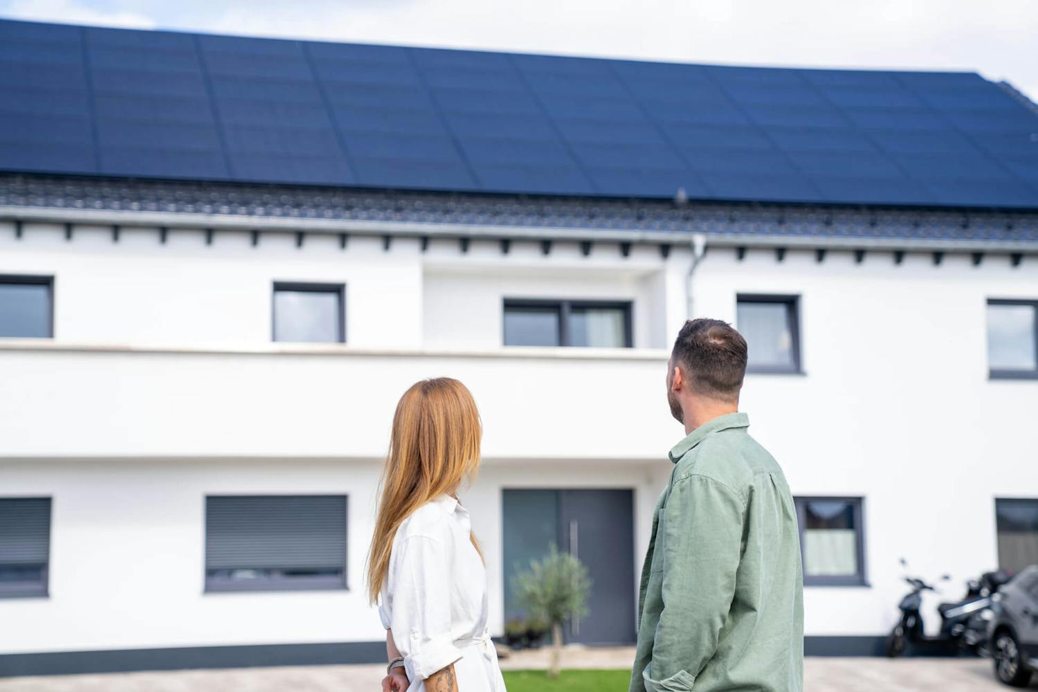 Paar, das sich ihre neue Solaranlage auf ihrem Haus in Nordrhein-Westfalen anschaut