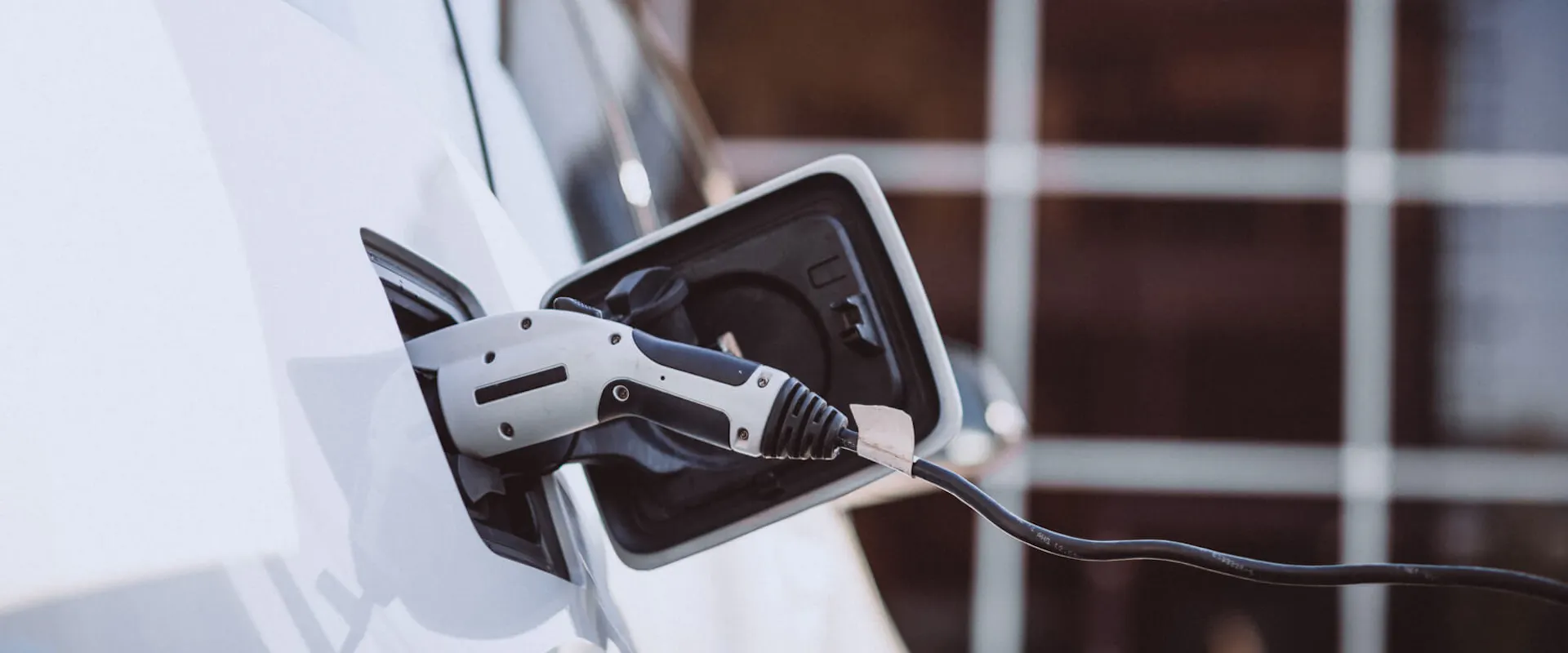 Weißes E-Auto, was gerade geladen wird Weißes E-Auto, was gerade geladen wird