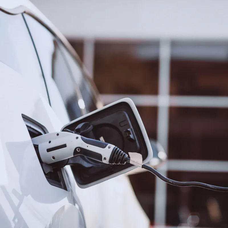 Weißes E-Auto, was gerade geladen wird Weißes E-Auto, was gerade geladen wird