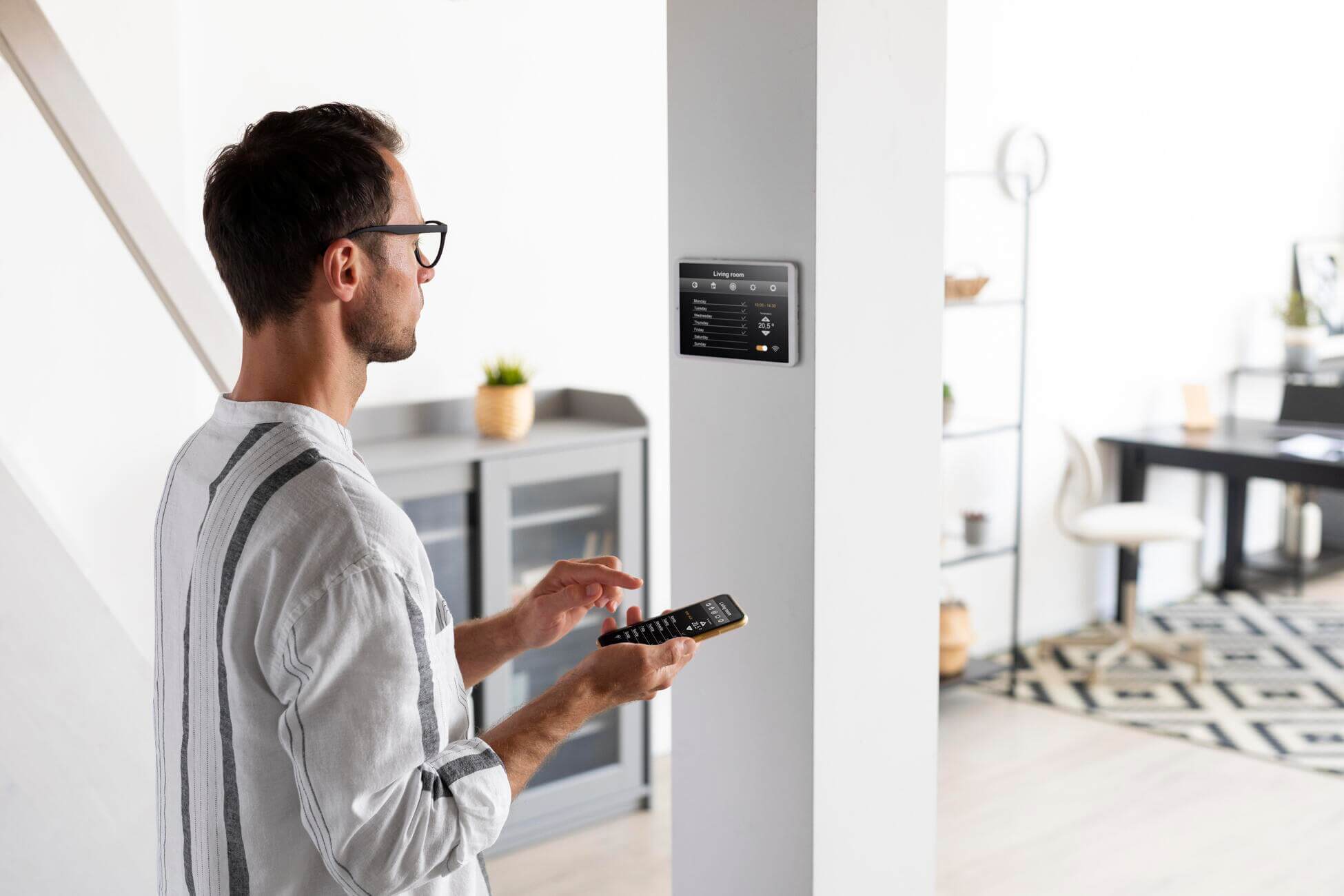 Person steuert Smart Home System, das mit einer intelligenten Wallbox verbunden ist
