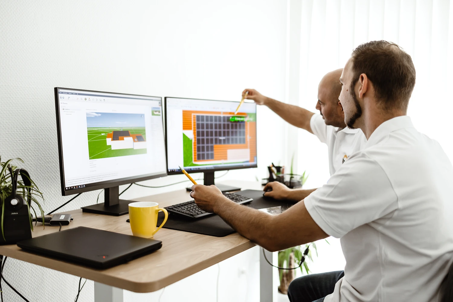 Planung eines Solaranlage-Komplettsets in 3D-Software durch zwei Gelb-Solar-Berater am Schreibtisch

