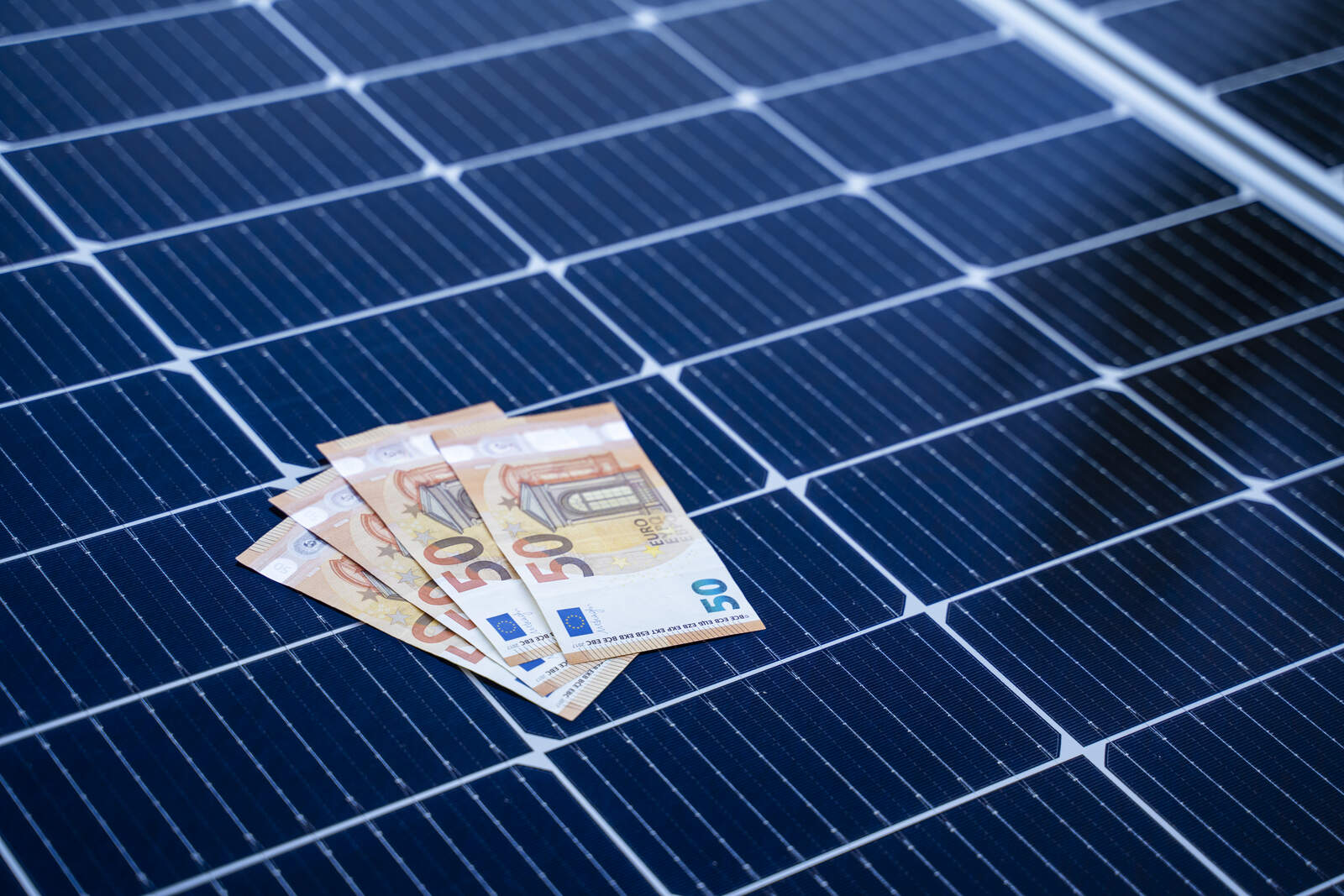 Vier 50-Euro-Scheine liegen auf einem Solarpanel – Symbolbild für die Wertsteigerung von Immobilien durch Photovoltaik
