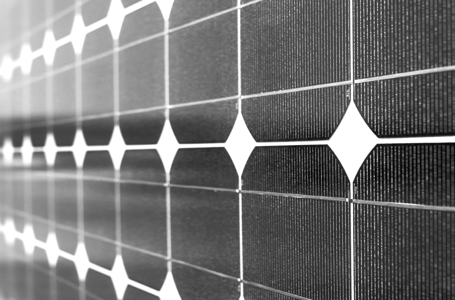 Nahaufnahme eines Solarmoduls mit monokristallinen Siliziumzellen, deren abgeschrägte Ecken rautenförmige Lücken bilden