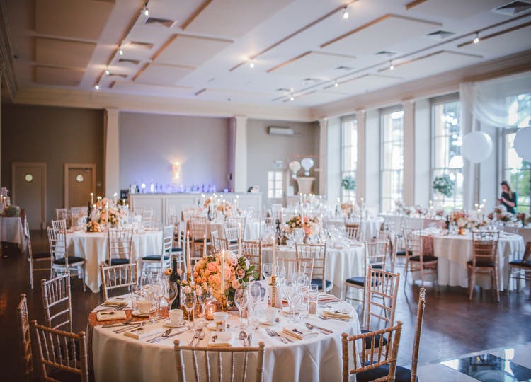 Düğün salonu içerisinde yuvarlak yemek masaları, sandalyeler, masaların üzerinde ise; mumlar, çiçekler, çatallar, bıçaklar ve bardaklar bulunuyor.