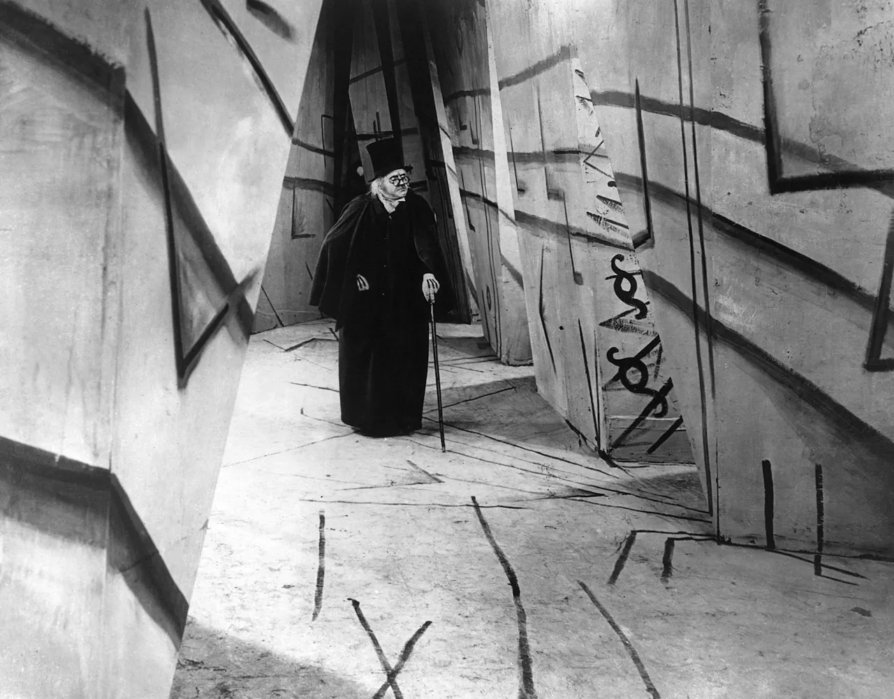 Publicity still from The Cabinet of Dr. Caligari (1920): painted shadows and tilted walls of the film's expressionist set. Public domain, via Wikimedia Commons.