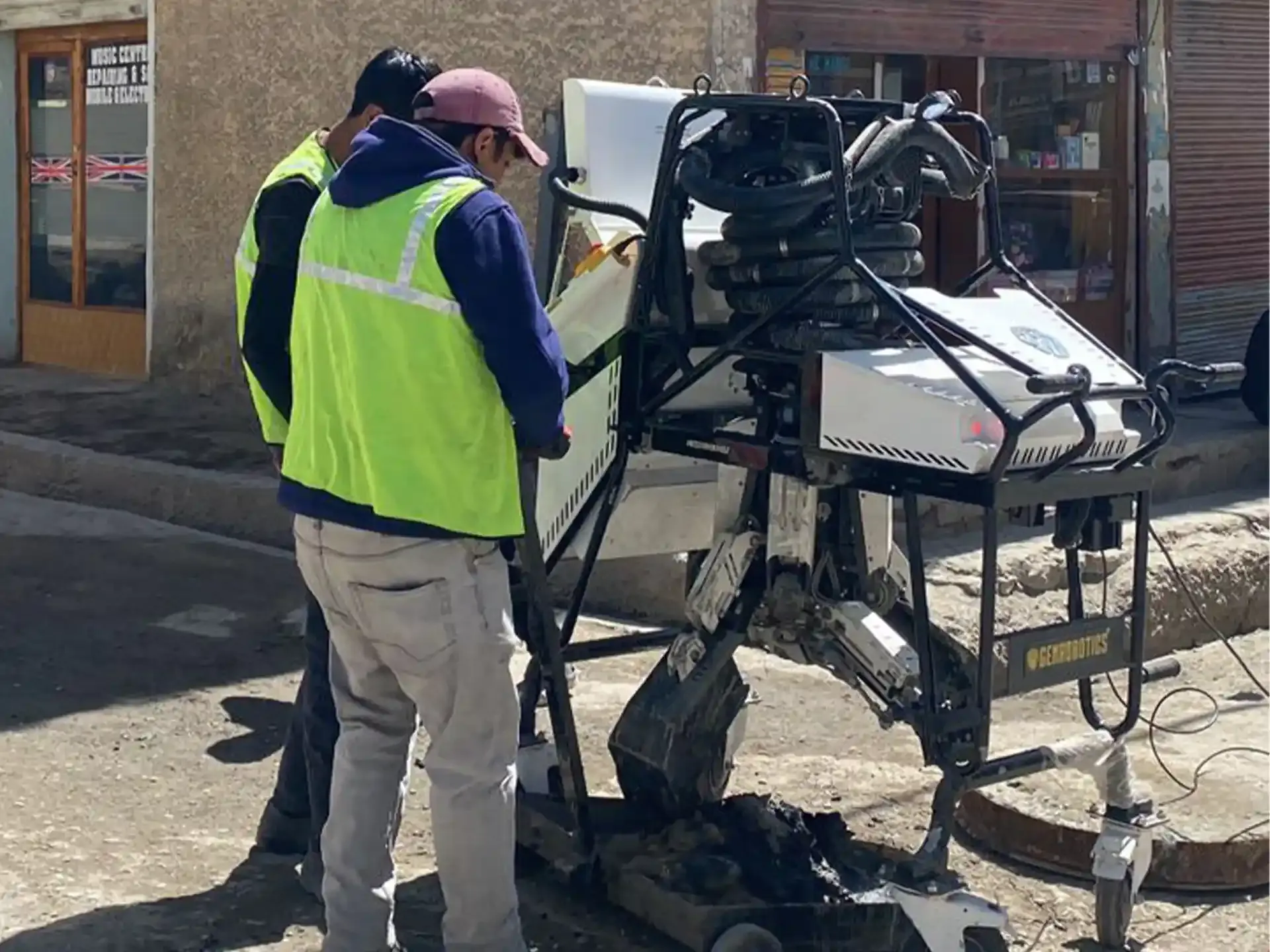 Operators manage a Bandicoot robotic system while it cleans a manhole in Leh, Ladakh under high altitude and extreme climate conditions.