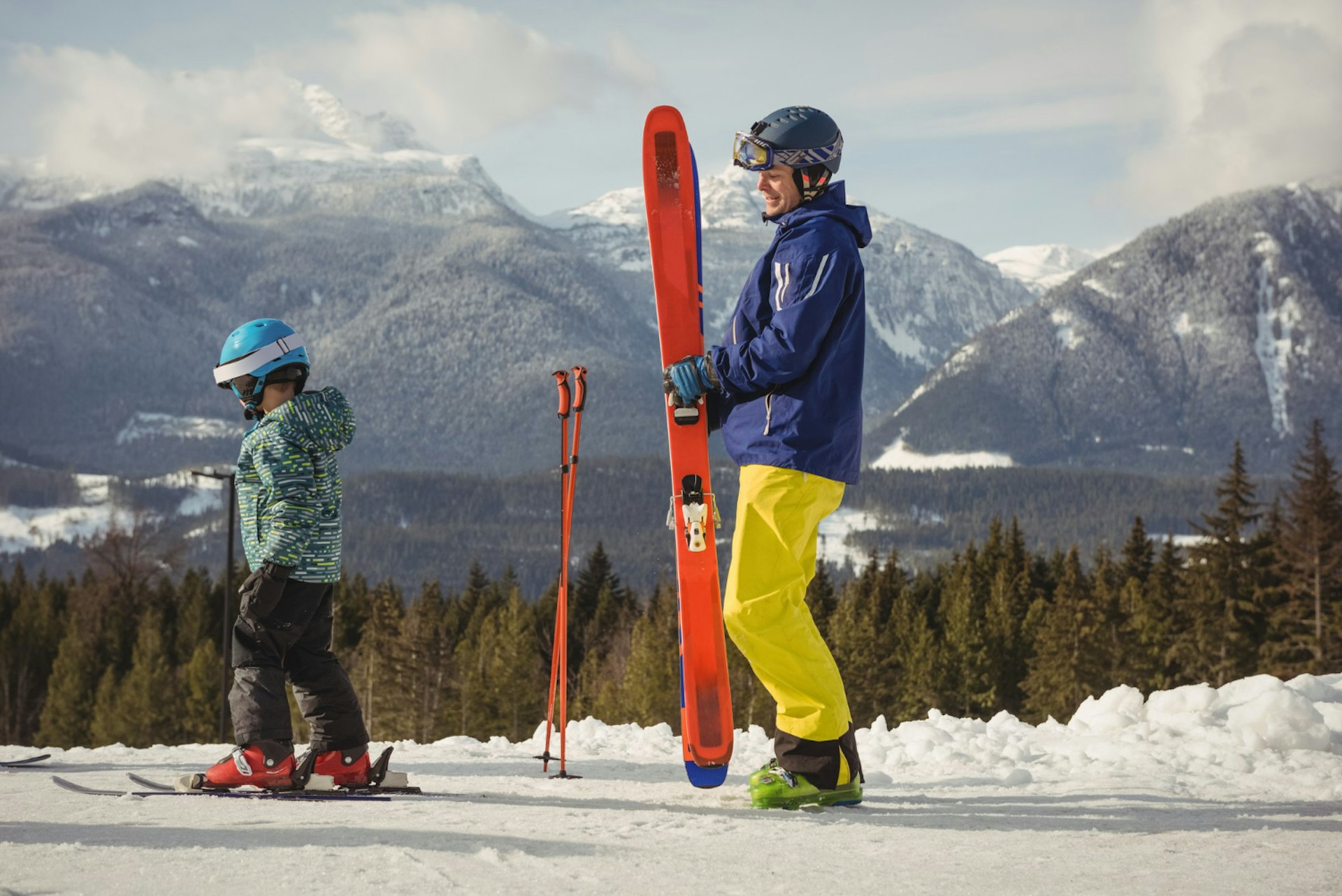 Father and daughter skiing on snowy mountain