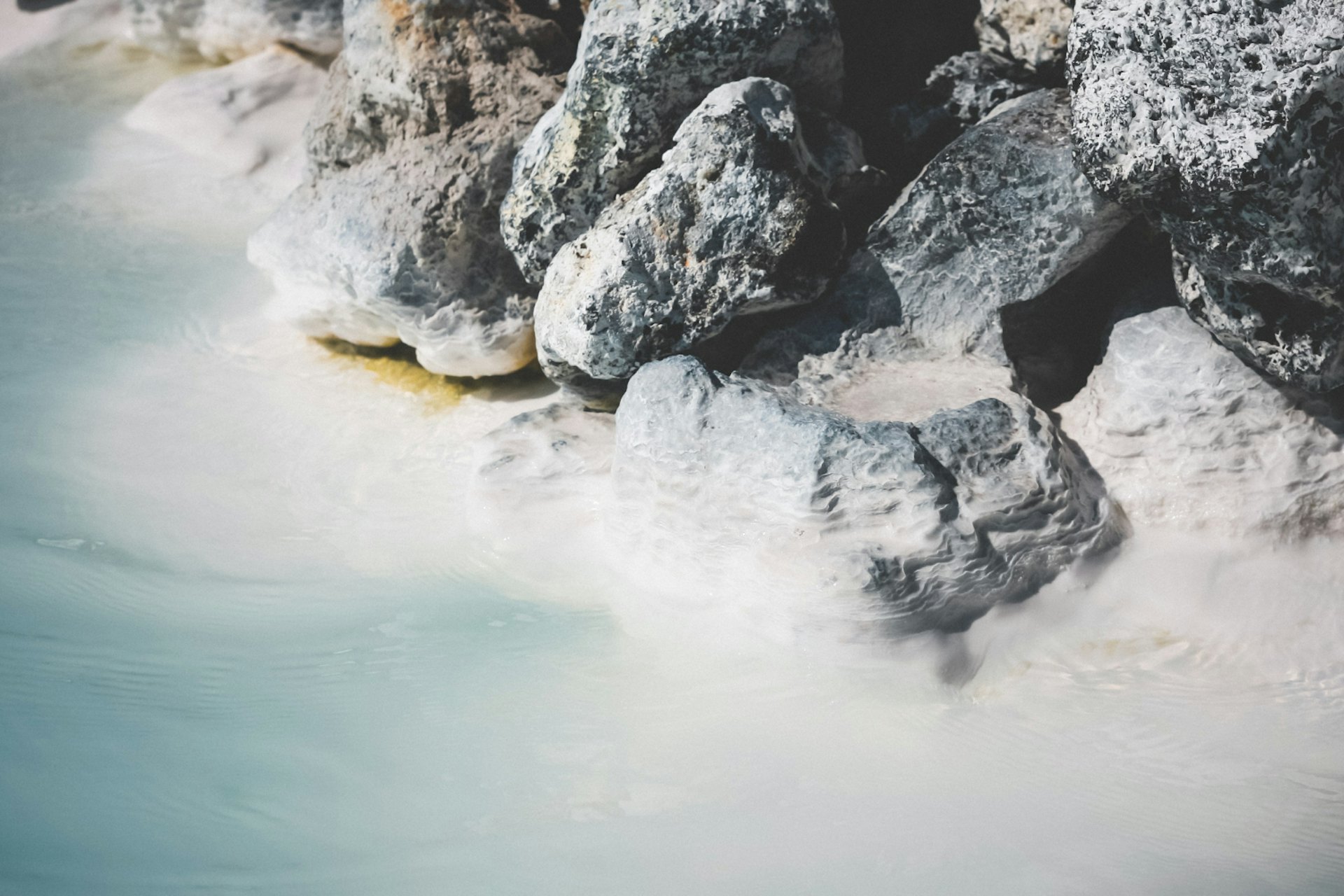 Beautiful shot of rocks stacked near a crystal clear water