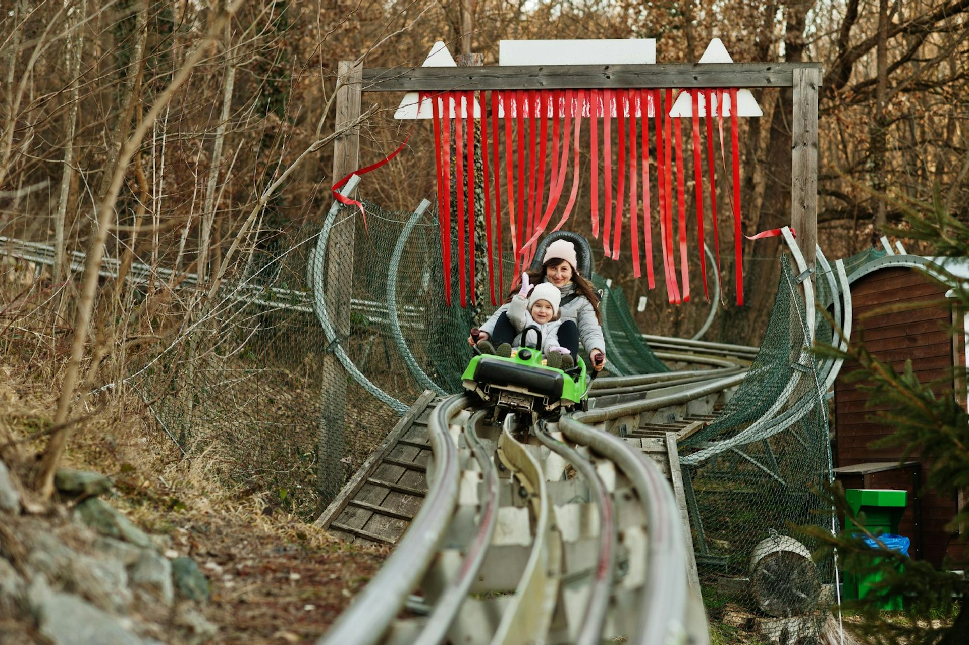 Mother with daughter ride electric sleigh on rails