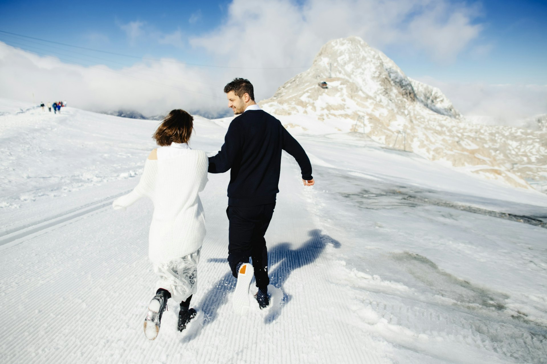 Happy husband and wife are somewhere running in the snow