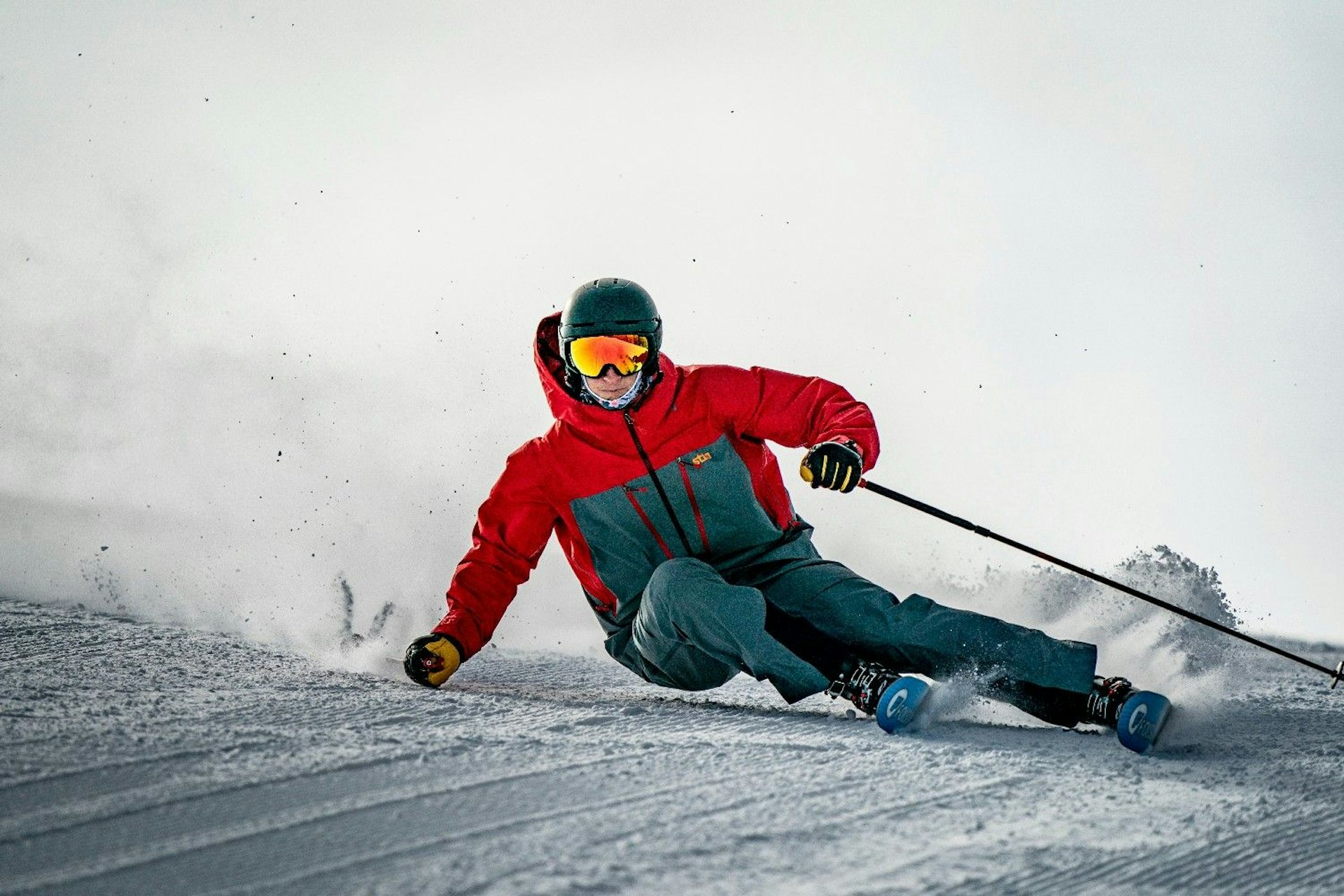 Male skier in red and gray ski attire hitting the slopes at Snowmass in Colorado, USA.