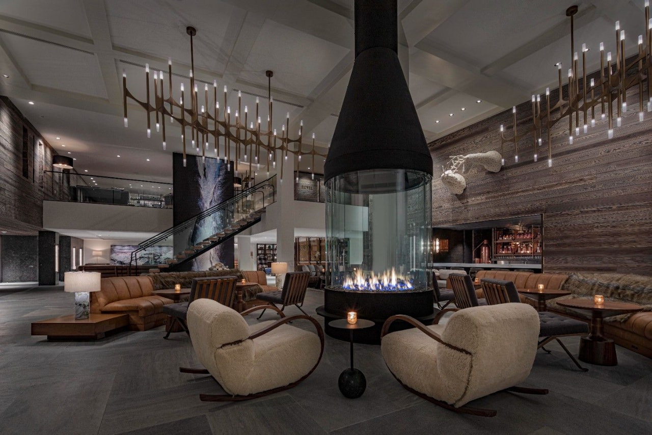 Stylish hotel lobby showcasing a fireplace and plush chairs, creating a welcoming atmosphere.