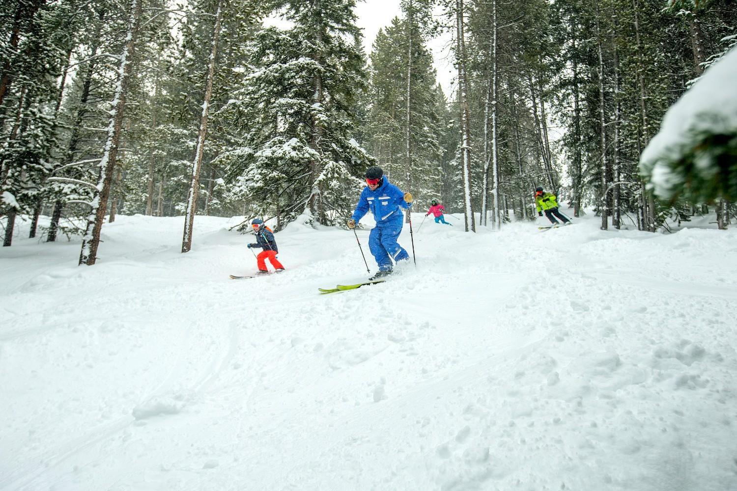 A group of skiers descends a snowy slope, showcasing their skills against a backdrop of winter scenery.