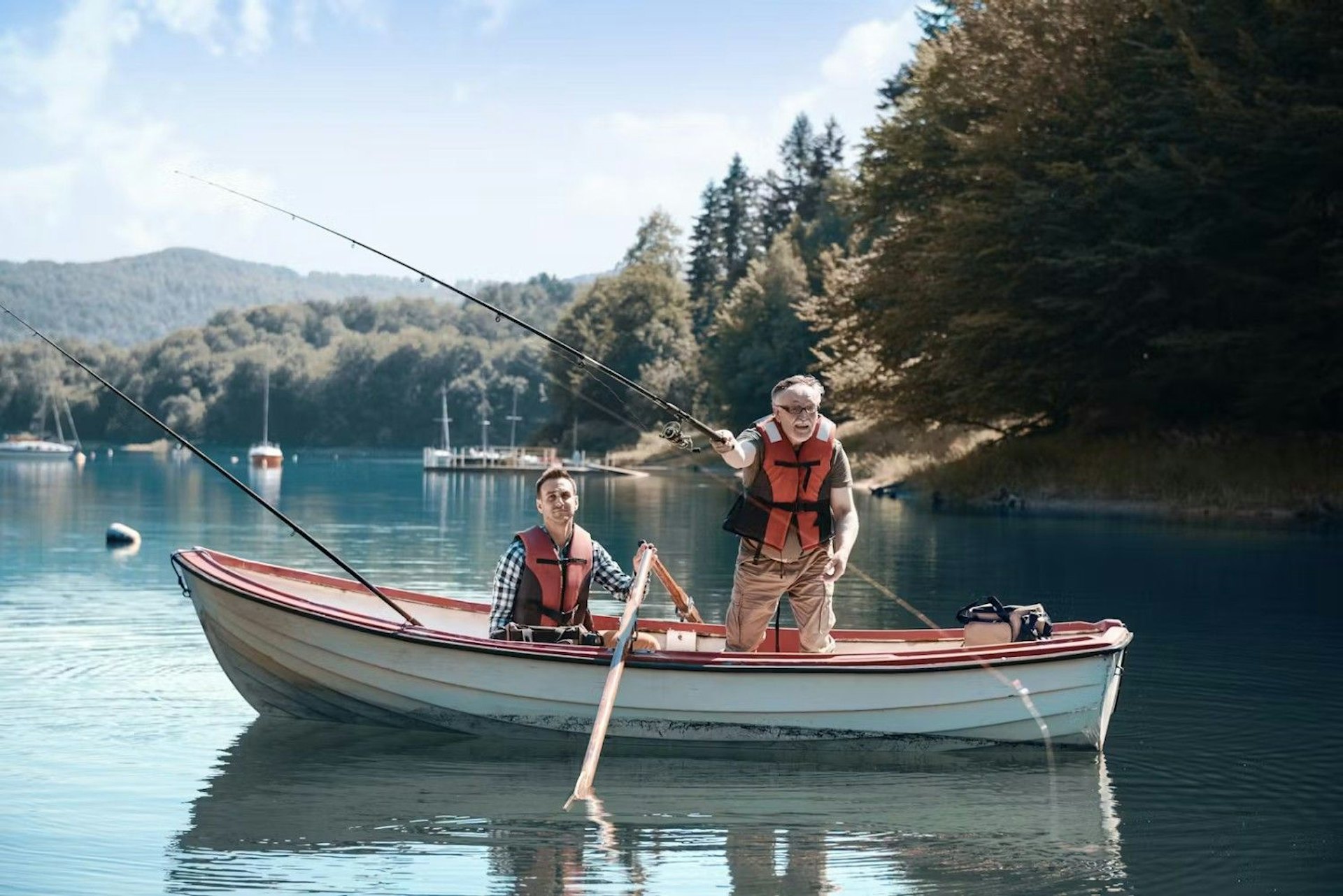 Two men enjoying fishing from a boat on a peaceful lake, with lush greenery in the background.
