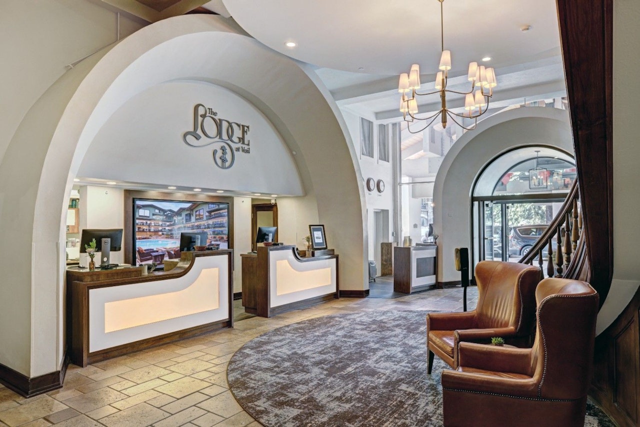 Hotel lobby featuring a spacious area with a prominent curved archway as a focal point.