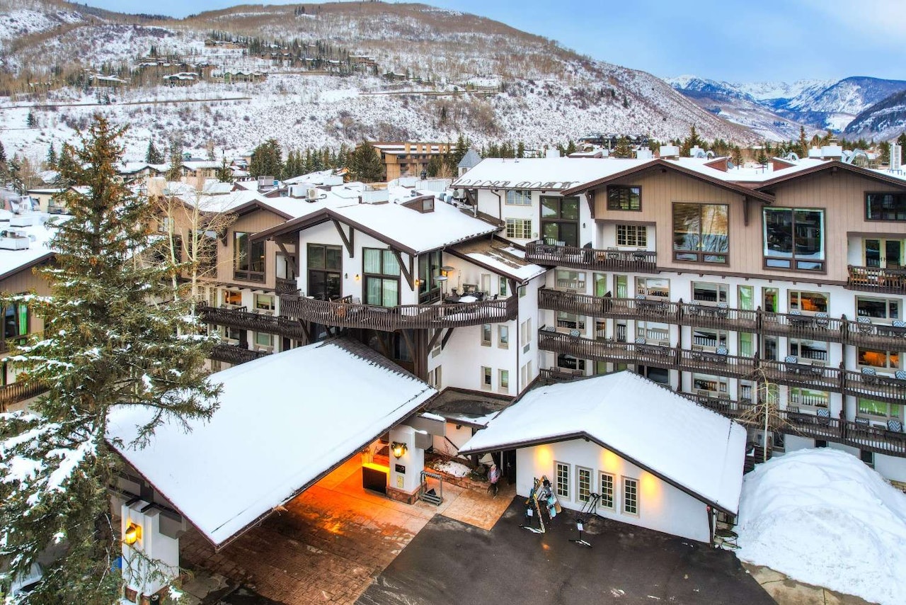 A hotel nestled among snow-covered mountains, showcasing a serene winter landscape.