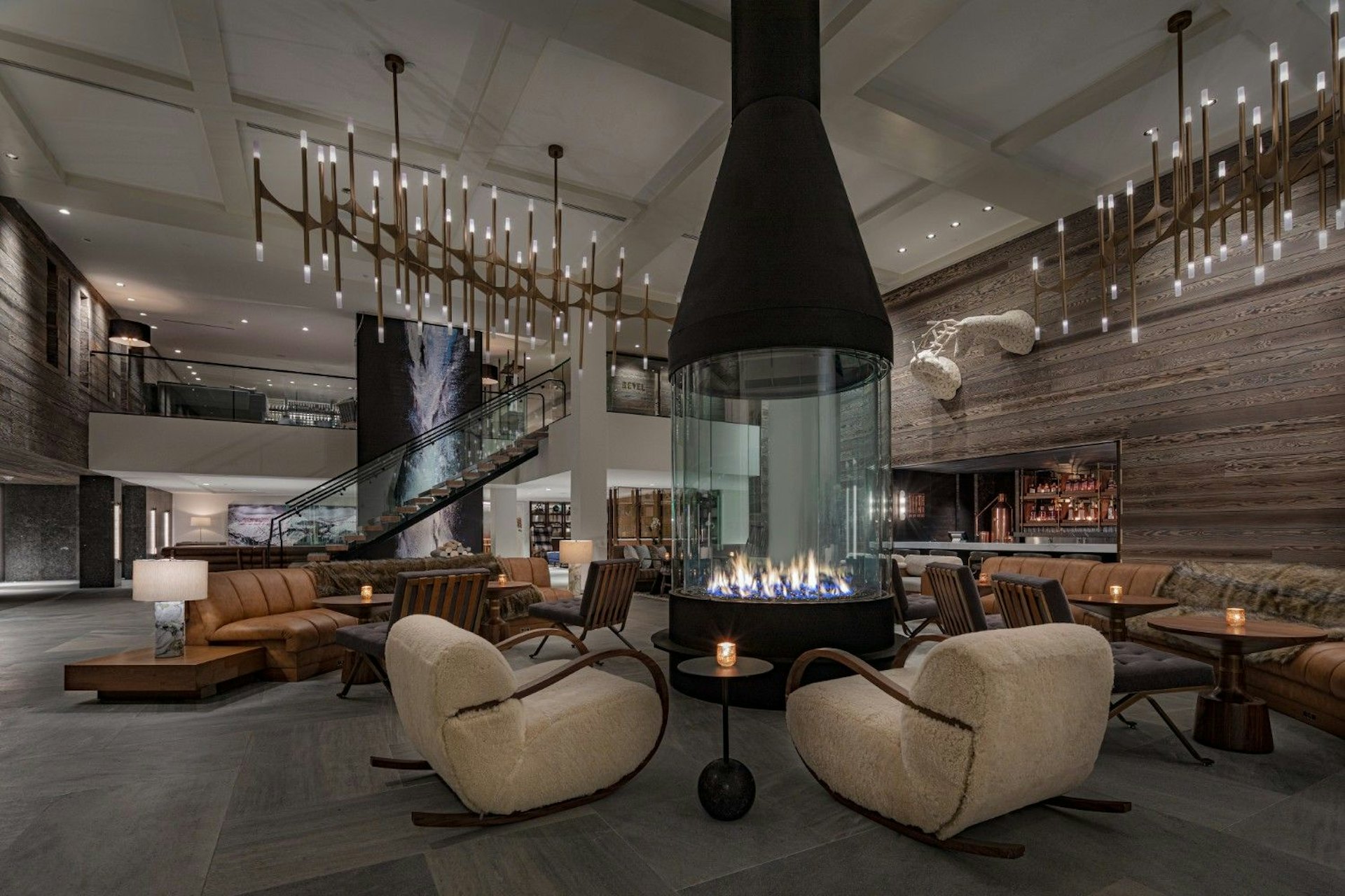 Hotel lobby featuring a cozy fireplace surrounded by comfortable chairs for guests to relax.