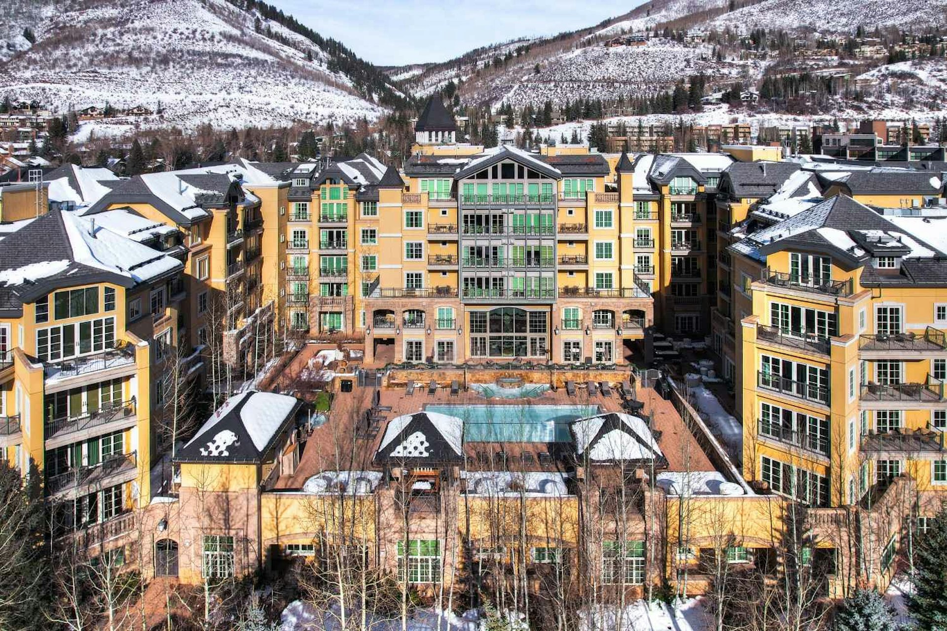 A snow-covered resort nestled at the base of a mountain, surrounded by a serene winter landscape.