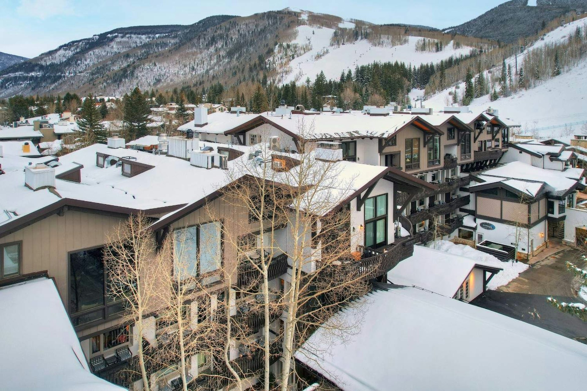 A snowy ski resort featuring several buildings surrounded by a winter landscape.