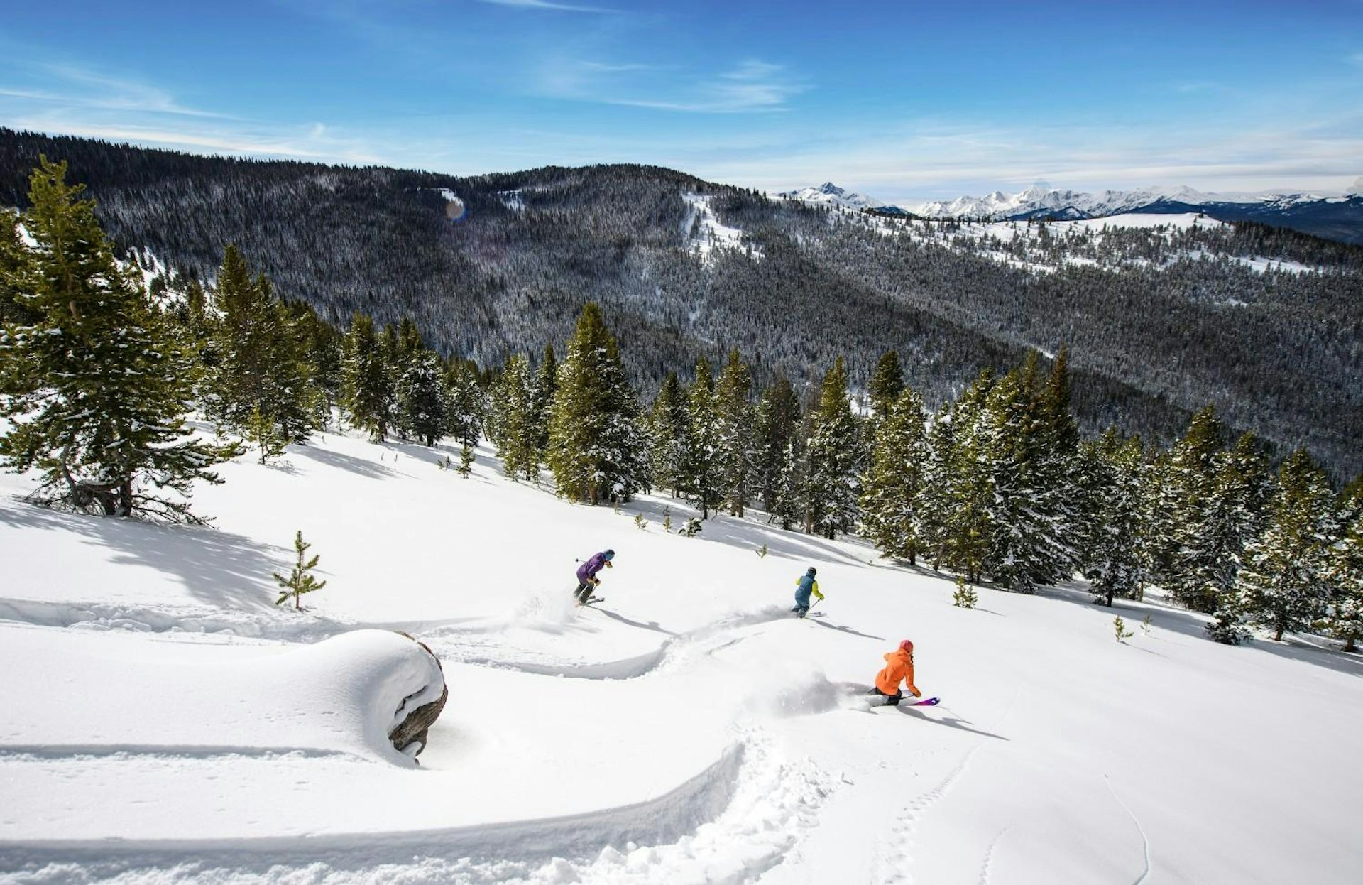 Three skiers navigate a snowy slope, showcasing their skills against a backdrop of winter scenery.